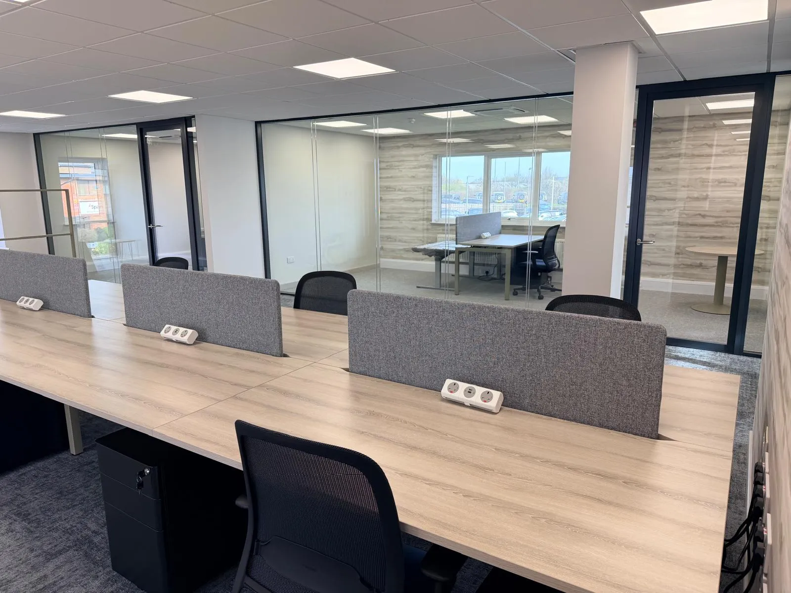 Workstation desks with privacy screens and frameless glass partitions at Boluda Towage