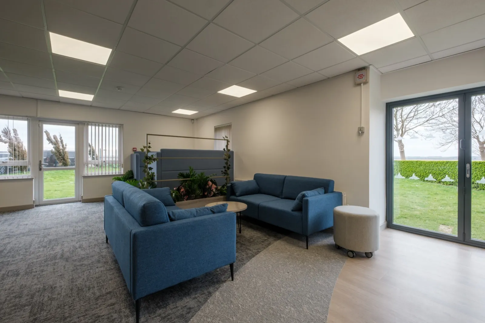 Waiting lounge with two blue sofas, planters and views across the estuary at Boluda Towage